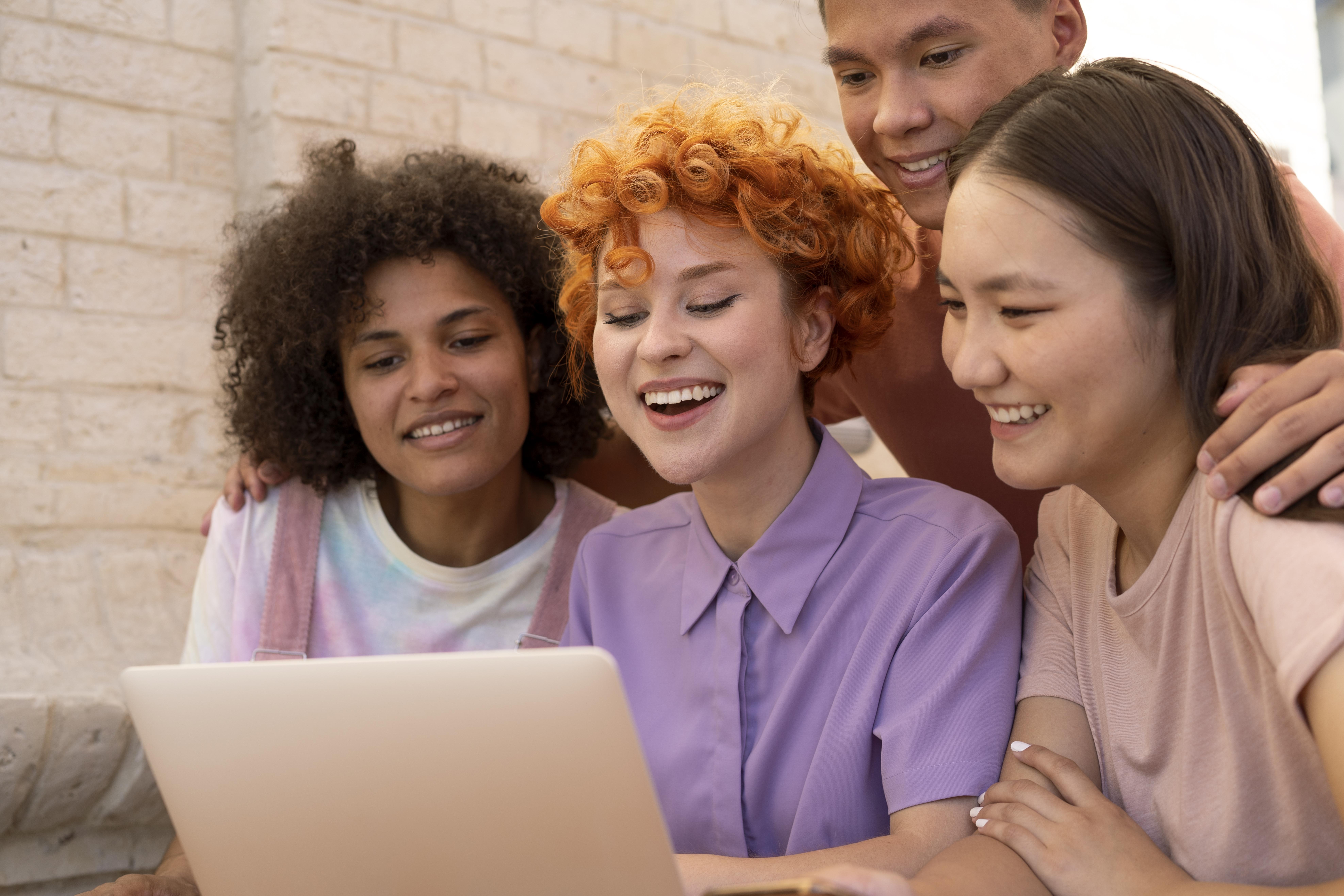 feche-amigos-sorridentes-com-laptop